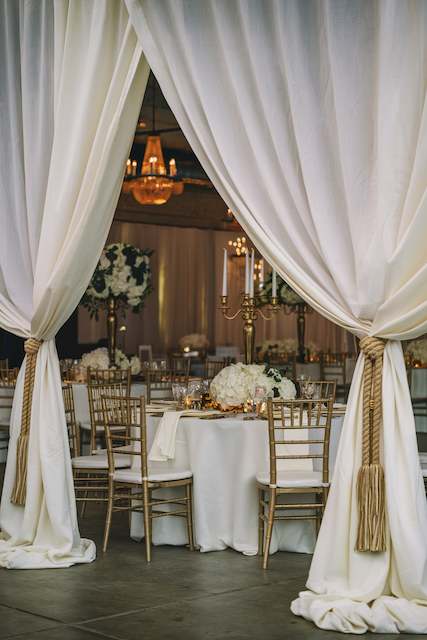 White Linen Drapes With Gold Rope Tiebacks.