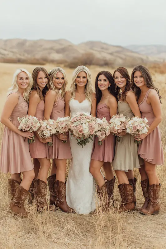 Bridesmaids Coordinated boot styles with mix-and-match dresses in western color palette Bridesmaids Coordinated boot styles with mix-and-match dresses in western color palette