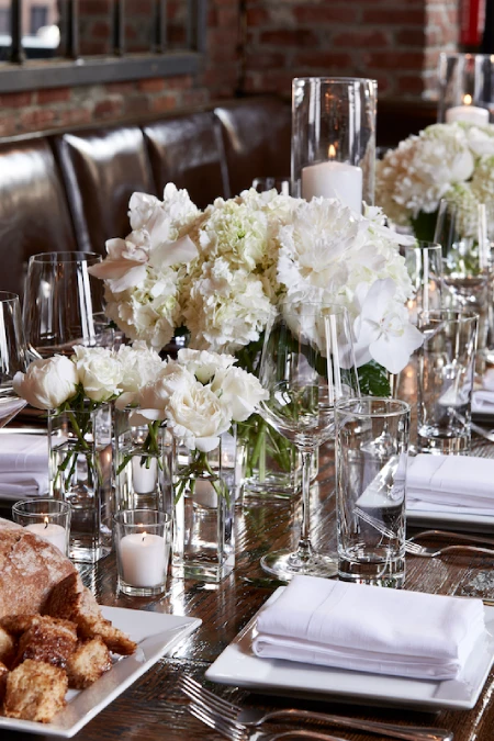 Elegant rehearsal dinner table with white florals, candlelight, and private dining room ambiance