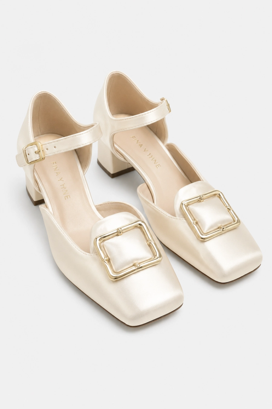 Wedding Shoes for the Bride: 27 Beautiful Ideas That Balance Style and Comfort 10 Ivory satin bridal Mary Jane heels with square toes, gold buckle accents, ankle straps, and block heels on white background