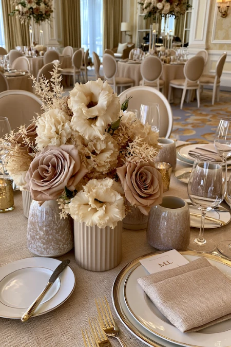 25 Fall Wedding Centerpieces With Main Character Energy (Cozy, Never Costume-y) 17 Neutral wedding centerpiece with taupe roses, ivory blooms, and ceramic bud vases on an elegant ballroom reception table