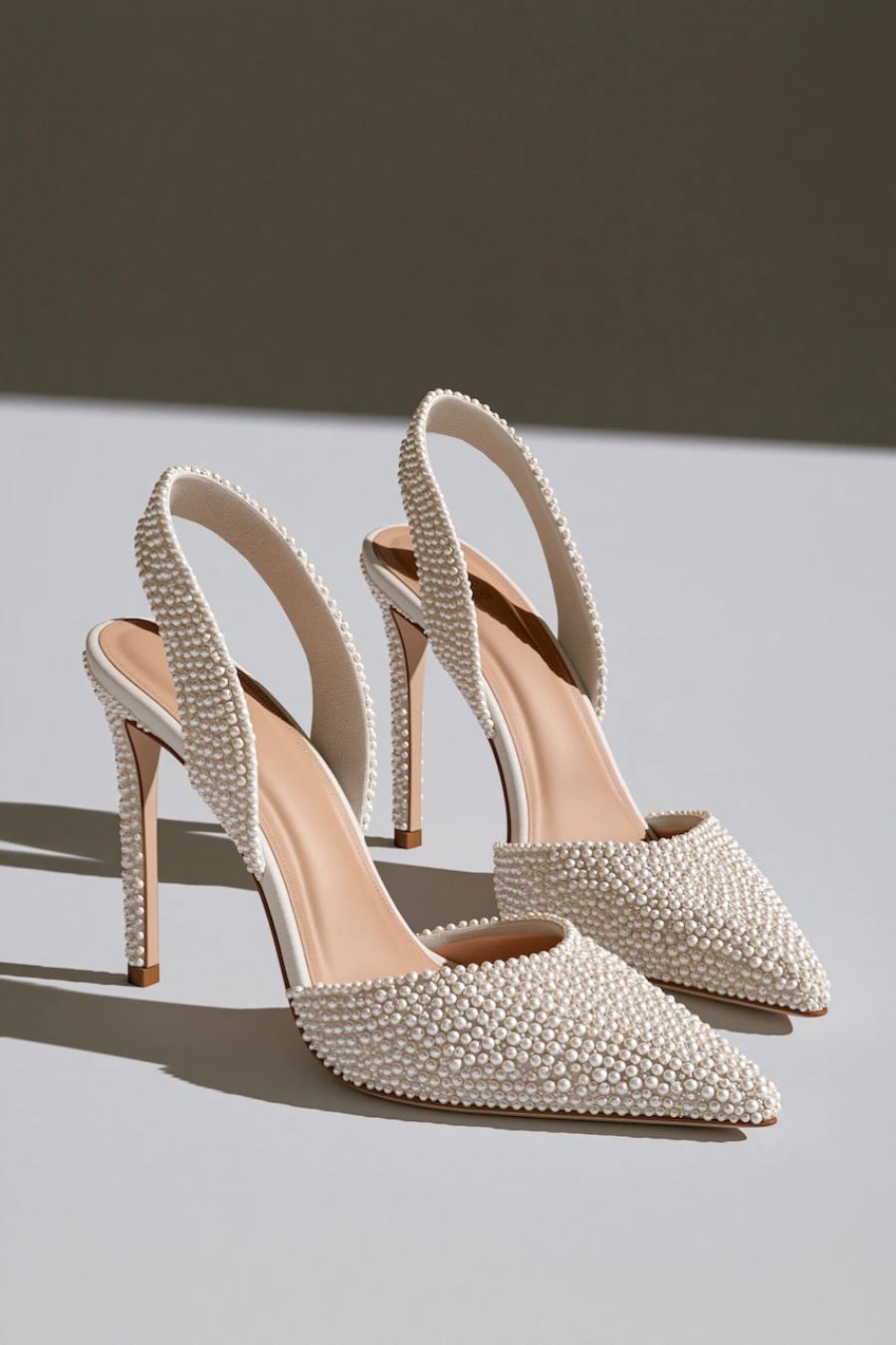 Wedding Shoes for the Bride: 27 Beautiful Ideas That Balance Style and Comfort 5 Pearl embellished slingback bridal heels with pointed toes and slim stilettos in a luxury studio product photography setting