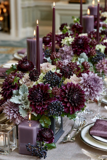 25 Fall Wedding Centerpieces With Main Character Energy (Cozy, Never Costume-y) 7 Moody plum and burgundy dahlia centerpiece with purple candles, berries, and lush florals on a luxury wedding table