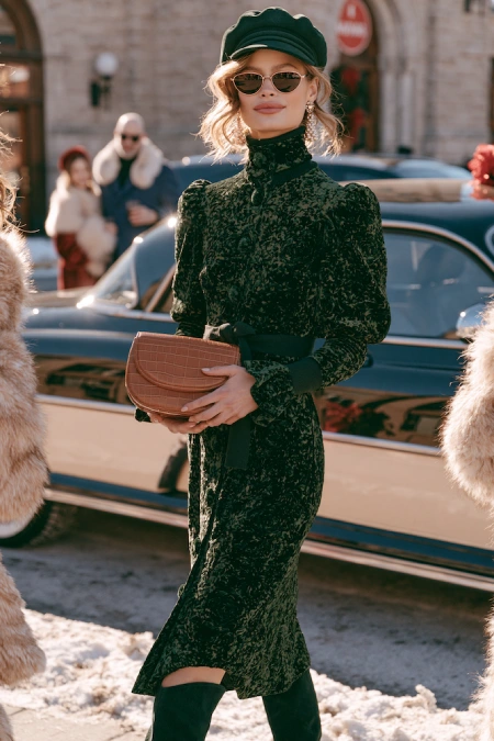 The Perfect Rehearsal Dinner Dress for Guests: Your Complete Outfit Guide 17 Woman in a black velvet dress with boots and beret styled for a chic winter rehearsal dinner in the city