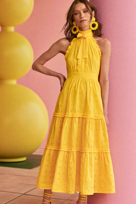 The Perfect Rehearsal Dinner Dress for Guests: Your Complete Outfit Guide 19 Woman in a vibrant yellow midi dress with statement earrings styled for a cheerful summer rehearsal dinner look
